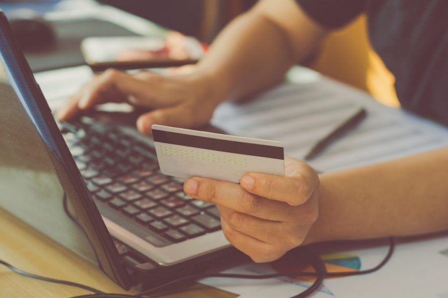 Hombre con una tarjeta de credito haciendo una compra online